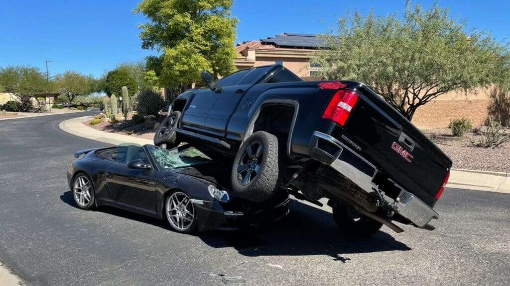 Pickup truck crashed on top of Porsche.